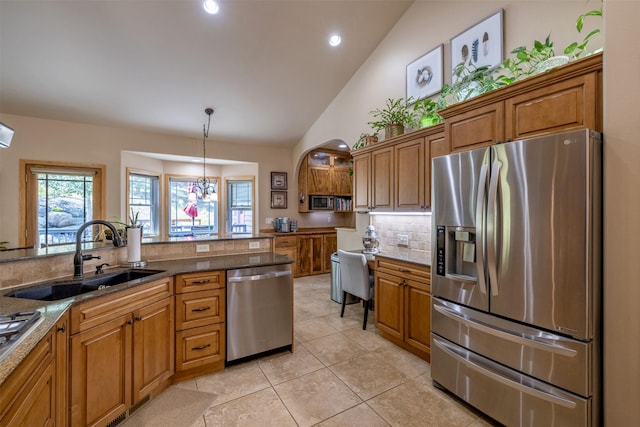 13 Crossfire Dr, Clancy, MT 59634 - kitchen with stainless steel appliances, tasteful backsplash, brown cabinets, vaulted ceiling, and dark stone countertops