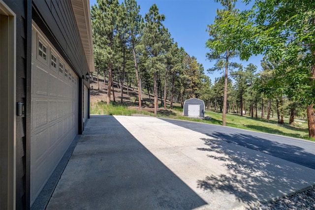 13 Crossfire Dr, Clancy, MT 59634 - view of patio with a storage shed, a garage, and view of wooded area