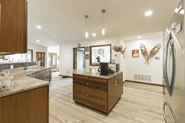 3979 Evenson Ln, Stevensville, MT 59870 - kitchen with stainless steel appliances, light wood-type flooring, pendant lighting, light stone countertops, and recessed lighting
