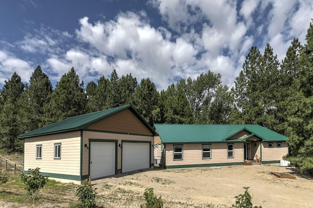 3979 Evenson Ln, Stevensville, MT 59870 - ranch-style home with a metal roof, an outbuilding, a detached garage, dirt driveway, and view of scattered trees