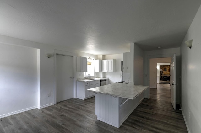 3979 Evenson Ln, Stevensville, MT 59870 - kitchen with stainless steel dishwasher, tile counters, dark wood-style flooring, and a kitchen breakfast bar