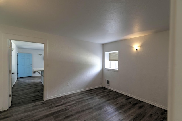 3979 Evenson Ln, Stevensville, MT 59870 - spare room featuring dark wood-style flooring and baseboards
