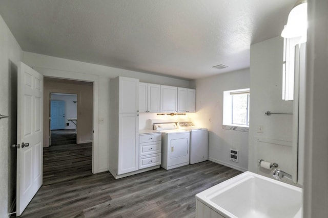 3979 Evenson Ln, Stevensville, MT 59870 - washroom featuring cabinet space, washing machine and dryer, dark wood-style flooring, a textured ceiling, and heating unit