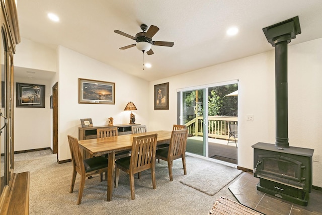 3979 Evenson Ln, Stevensville, MT 59870 - dining room featuring a wood stove, a ceiling fan, vaulted ceiling, recessed lighting, and light colored carpet