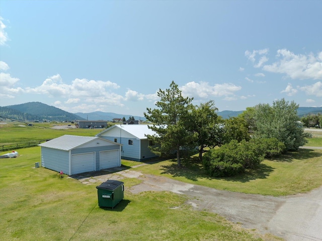 3250 US Highway 2 W, Kalispell, MT 59901 - view of side of property with a garage, a mountain view, and an outbuilding