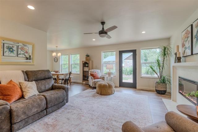 405 Kendal Loop, Kalispell, MT 59901 - living area with wood finished floors, a fireplace with flush hearth, recessed lighting, a ceiling fan, and a chandelier