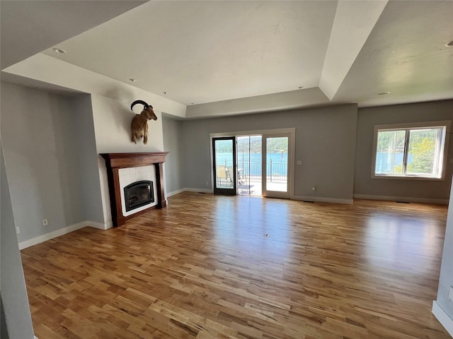 37 Roybals Way, Kalispell, MT 59901 - unfurnished living room with wood finished floors, a fireplace, and a raised ceiling