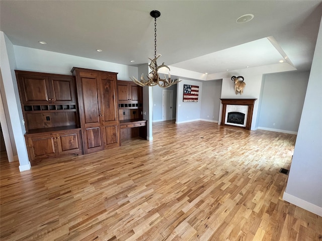 37 Roybals Way, Kalispell, MT 59901 - unfurnished living room with a chandelier, light wood-style flooring, a fireplace, and recessed lighting