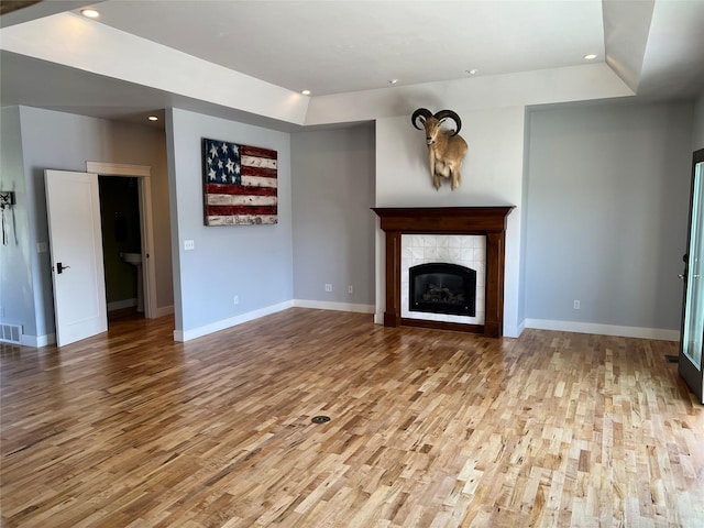 37 Roybals Way, Kalispell, MT 59901 - unfurnished living room with recessed lighting, wood finished floors, a raised ceiling, and a tile fireplace
