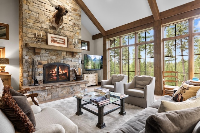 176 Whitefish Hills Loop, Whitefish, MT 59937 - living area with a stone fireplace, beam ceiling, healthy amount of natural light, and high vaulted ceiling