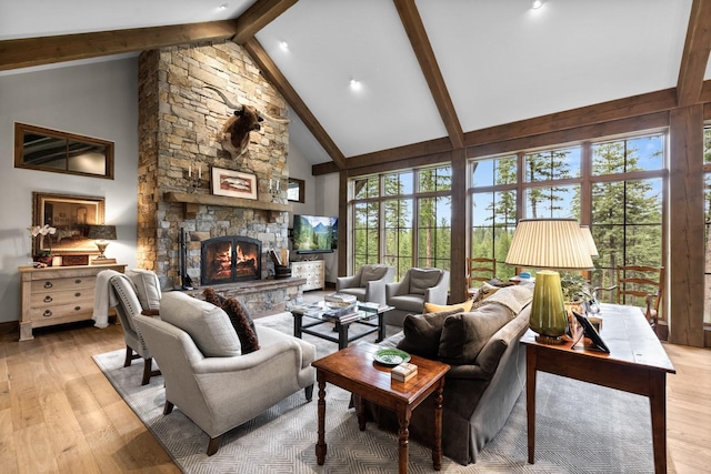176 Whitefish Hills Loop, Whitefish, MT 59937 - living area with beamed ceiling, a stone fireplace, light wood-style flooring, and high vaulted ceiling