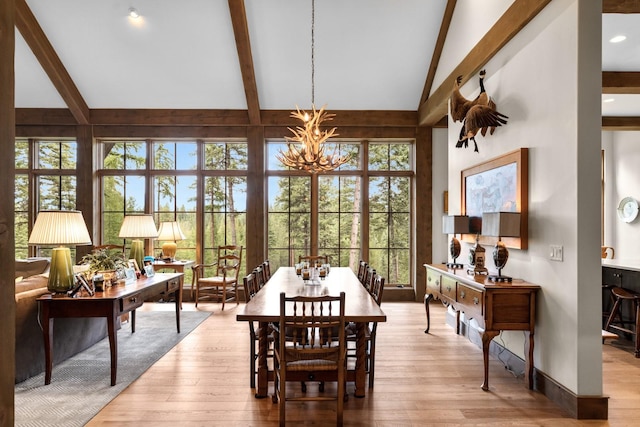 176 Whitefish Hills Loop, Whitefish, MT 59937 - dining room featuring a chandelier, beam ceiling, wood finished floors, plenty of natural light, and high vaulted ceiling