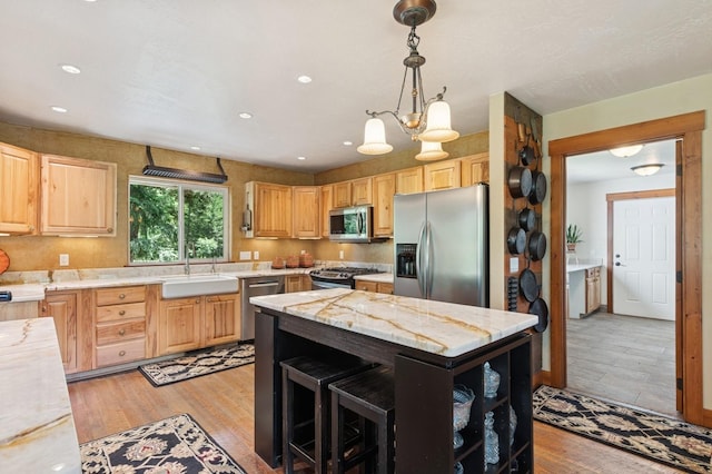 745 Capistrano Dr, Kalispell, MT 59901 - kitchen with stainless steel appliances, light brown cabinetry, decorative light fixtures, recessed lighting, and light wood finished floors