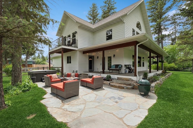 745 Capistrano Dr, Kalispell, MT 59901 - back of property featuring a balcony, a hot tub, an outdoor living space, and a patio