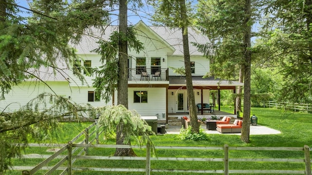 745 Capistrano Dr, Kalispell, MT 59901 - back of property with a fenced backyard, an outdoor hangout area, a patio area, a balcony, and a shingled roof