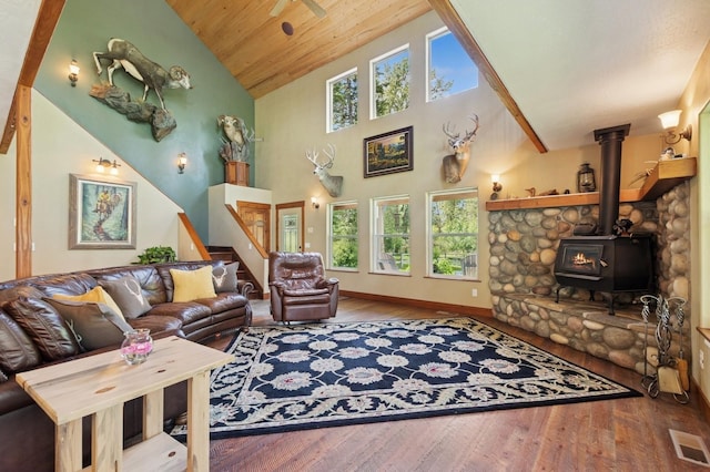 745 Capistrano Dr, Kalispell, MT 59901 - living room with high vaulted ceiling, wood finished floors, stairs, a wood stove, and wood ceiling