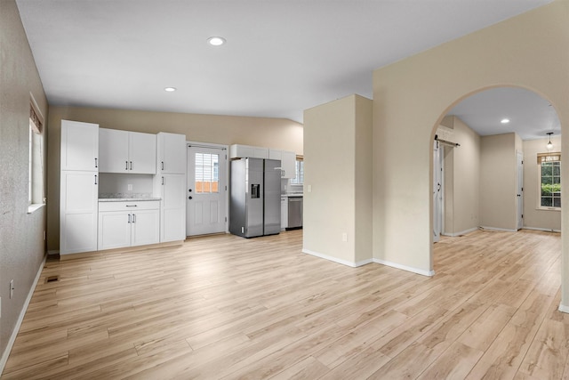 4012 Lancaster Rd, Missoula, MT 59808 - unfurnished living room featuring arched walkways, light wood-style floors, recessed lighting, and a barn door