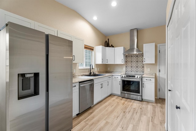 4012 Lancaster Rd, Missoula, MT 59808 - kitchen with stainless steel appliances, wall chimney exhaust hood, white cabinetry, light wood finished floors, and recessed lighting