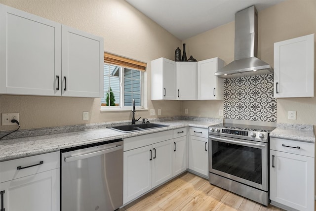 4012 Lancaster Rd, Missoula, MT 59808 - kitchen featuring appliances with stainless steel finishes, wall chimney range hood, white cabinets, light wood-style floors, and a textured wall