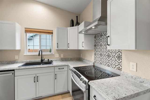 4012 Lancaster Rd, Missoula, MT 59808 - kitchen with wall chimney range hood, stainless steel appliances, white cabinets, light wood-type flooring, and a textured wall