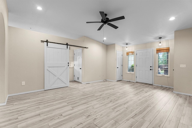 4012 Lancaster Rd, Missoula, MT 59808 - unfurnished living room featuring a barn door, a ceiling fan, light wood-style flooring, and recessed lighting