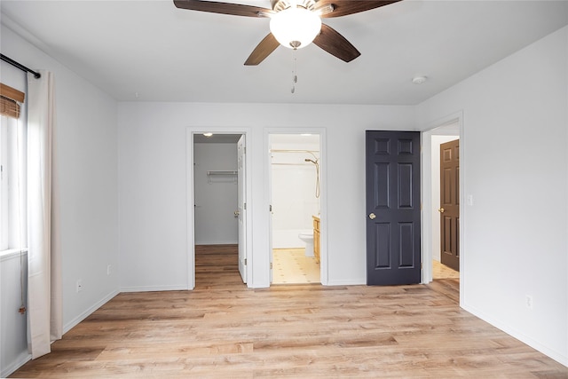 3477 Birkland Dr, Helena, MT 59602 - unfurnished bedroom with light wood-style floors, ensuite bathroom, a spacious closet, a ceiling fan, and a closet