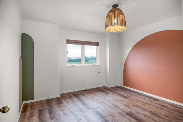 3477 Birkland Dr, Helena, MT 59602 - empty room featuring arched walkways and wood finished floors