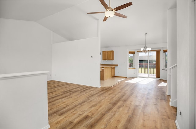 3477 Birkland Dr, Helena, MT 59602 - unfurnished living room with vaulted ceiling, ceiling fan, light wood-style floors, and a chandelier