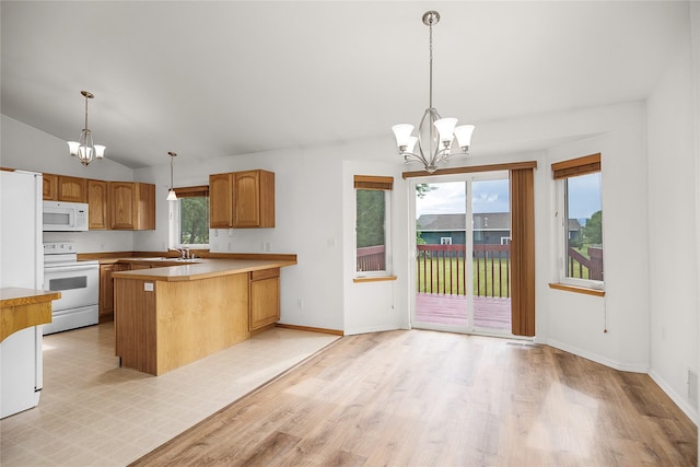 3477 Birkland Dr, Helena, MT 59602 - kitchen featuring white appliances, a chandelier, a peninsula, vaulted ceiling, and light countertops