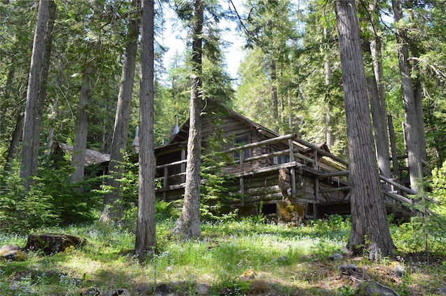 489 Grist Rd, West Glacier, MT 59936 - back of house with log exterior, a deck, and a forest view