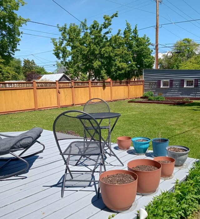 905 3rd Ave E, Kalispell, MT 59901 - wooden terrace with a fenced backyard, an outdoor structure, and outdoor dining area