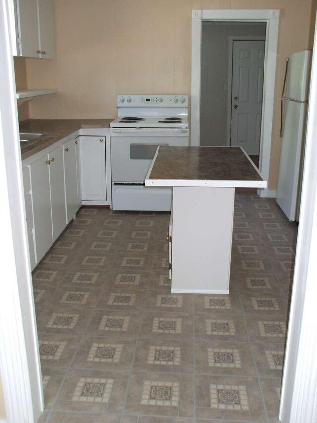 905 3rd Ave E, Kalispell, MT 59901 - kitchen with white appliances, white cabinetry, and a center island