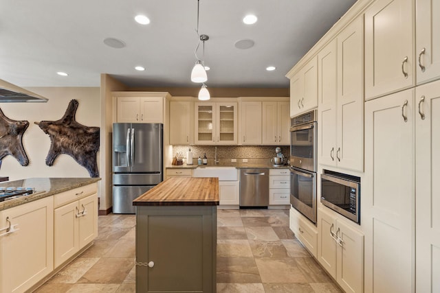 71 Cw Mitchell Ct, Marion, MT 59925 - kitchen with appliances with stainless steel finishes, wooden counters, backsplash, hanging light fixtures, and glass insert cabinets