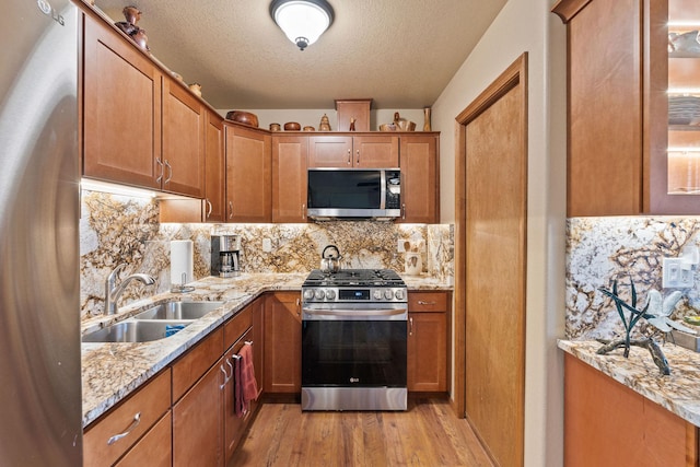 71 Cw Mitchell Ct, Marion, MT 59925 - kitchen featuring stainless steel appliances, light wood-type flooring, decorative backsplash, a textured ceiling, and light stone countertops