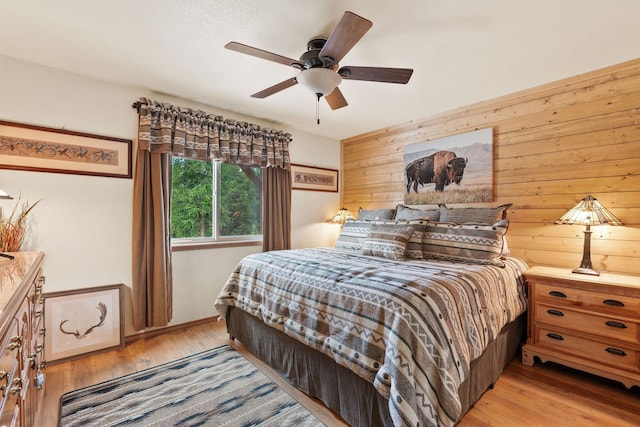 71 Cw Mitchell Ct, Marion, MT 59925 - bedroom with wooden walls, light wood-type flooring, and a ceiling fan
