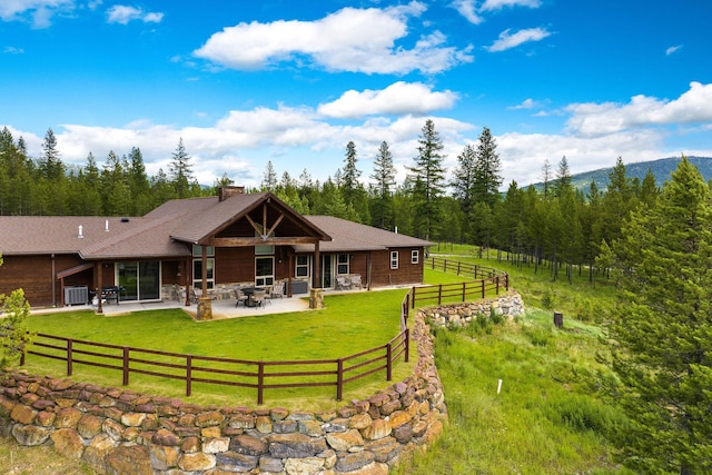 71 Cw Mitchell Ct, Marion, MT 59925 - back of house with a patio area, a chimney, a forest view, and stone siding