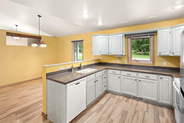 133 Trailridge Rd, Kalispell, MT 59901 - kitchen with white dishwasher, a peninsula, dark countertops, plenty of natural light, and vaulted ceiling