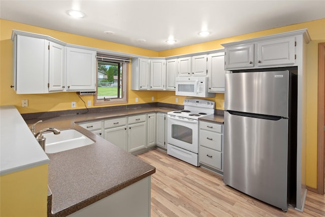 133 Trailridge Rd, Kalispell, MT 59901 - kitchen featuring white appliances, dark countertops, light wood-type flooring, recessed lighting, and white cabinetry