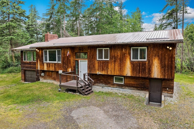 1255 Tamarack Ln, Columbia Falls, MT 59912 - split foyer home featuring a metal roof, a garage, and a chimney