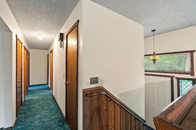 1255 Tamarack Ln, Columbia Falls, MT 59912 - hall featuring a textured ceiling, dark carpet, and an upstairs landing