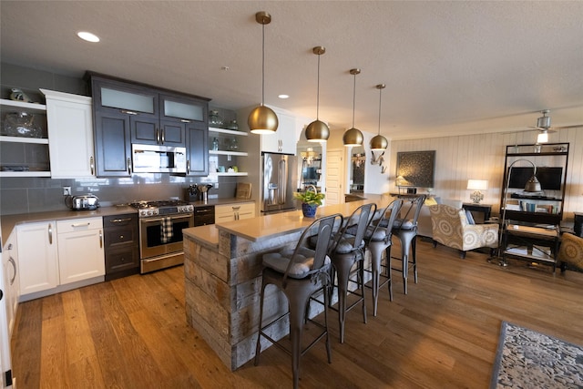 7175 US Highway 93 S, Lakeside, MT 59922 - kitchen with stainless steel appliances, open shelves, dark wood-style floors, tasteful backsplash, and recessed lighting