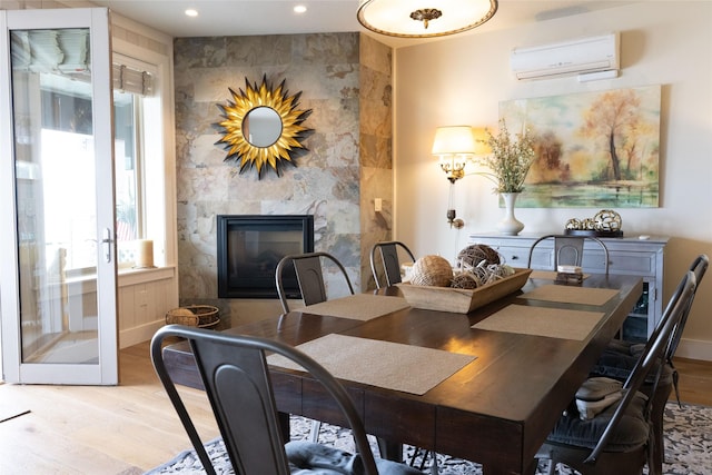 7175 US Highway 93 S, Lakeside, MT 59922 - dining room with a wall mounted air conditioner, light wood-style floors, recessed lighting, and a large fireplace
