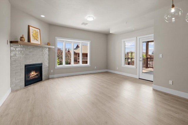 6201 Shiloh Ave Unit G, Whitefish, MT 59937 - unfurnished living room featuring healthy amount of natural light, wood finished floors, a brick fireplace, and recessed lighting