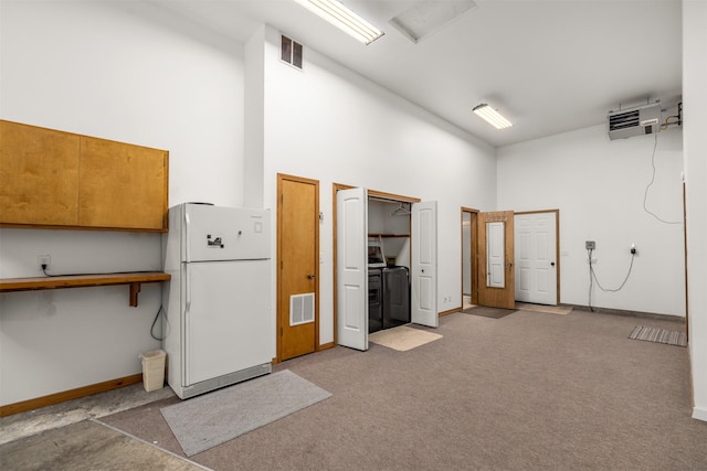 2206 US Highway 2 W, Kalispell, MT 59901 - garage featuring freestanding refrigerator, a heating unit, and washer and clothes dryer
