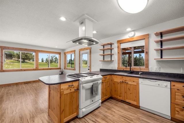 2206 US Highway 2 W, Kalispell, MT 59901 - kitchen with white appliances, open shelves, island range hood, a peninsula, and light wood-style flooring