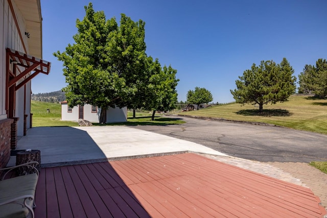 2206 US Highway 2 W, Kalispell, MT 59901 - wooden deck featuring a patio area, a lawn, and a storage unit