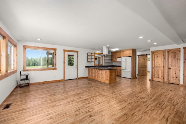 2206 US Highway 2 W, Kalispell, MT 59901 - kitchen with white appliances, island range hood, dark countertops, light wood-type flooring, and recessed lighting