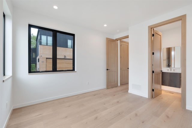 134 2nd St W Unit B, Whitefish, MT 59937 - unfurnished bedroom with light wood-style flooring, recessed lighting, and connected bathroom
