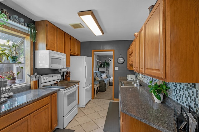2321 8th Ave S, Great Falls, MT 59405 - kitchen featuring white appliances, dark countertops, decorative backsplash, and light tile patterned floors