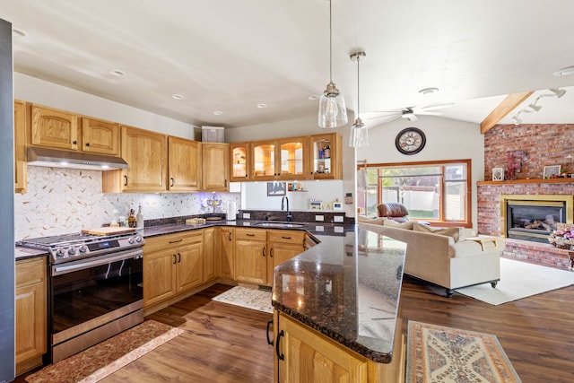 2604 5th Ave S, Great Falls, MT 59405 - kitchen featuring stainless steel gas stove, under cabinet range hood, dark wood finished floors, ceiling fan, and a peninsula